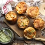 Goat's Cheese Yorkshire Puddings with Lemon Chives Butter on a wooden board with a glass of Sauvignon blanc