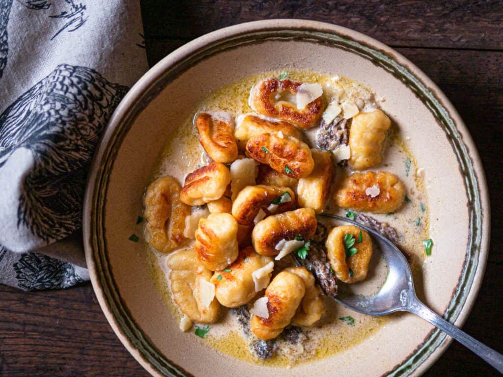 Crispy potato gnocchi with creamy morel sauce in a bowl