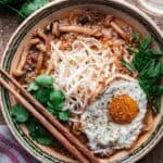 ramen in a bowl with a fried egg and chopsticks.