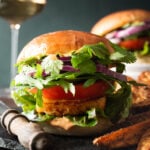 halloumi burgers with some potato wedges on the side and a glass of white wine