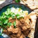 vegan paneer butter masala in bowl with naan bread.