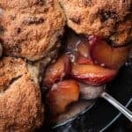 close-up of the baked peaches of a peach cobbler in a cast iron skillet