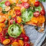 puff pastry heirloom tomato tart with whipped feta with a slice cut off.