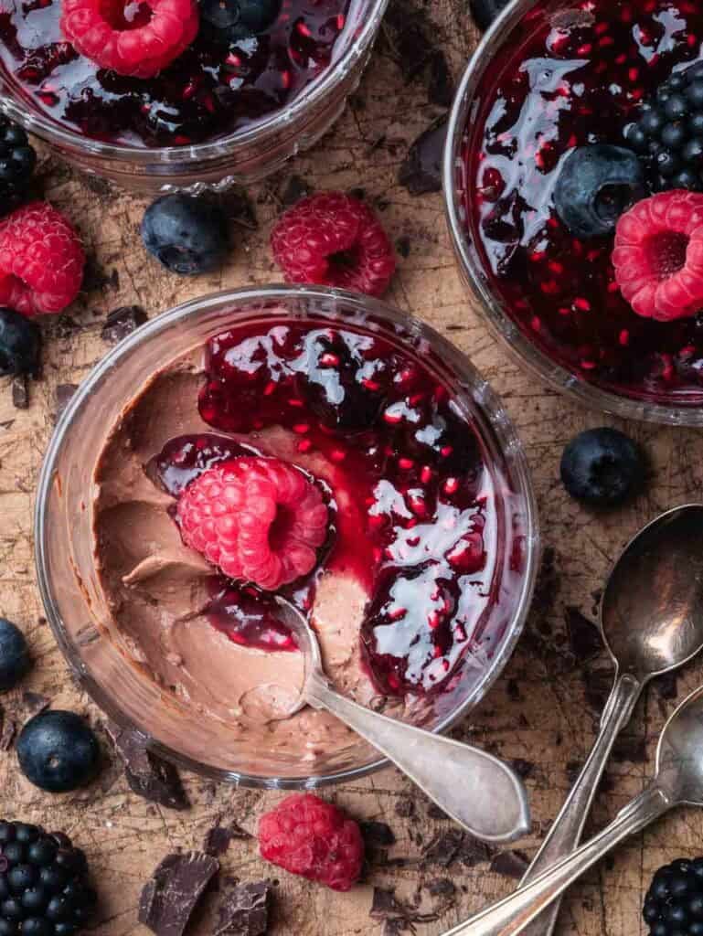 a half-eaten chocolate panna cotta with berry compote.