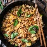 Hibachi rice in a braiser with chopsticks and a glass of white wine on the side
