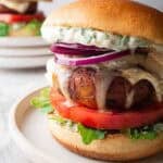 portobello mushroom burger with melted goat cheese on a white plate.