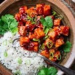spicy crunchy tofu with gochujang on a plate with rice.