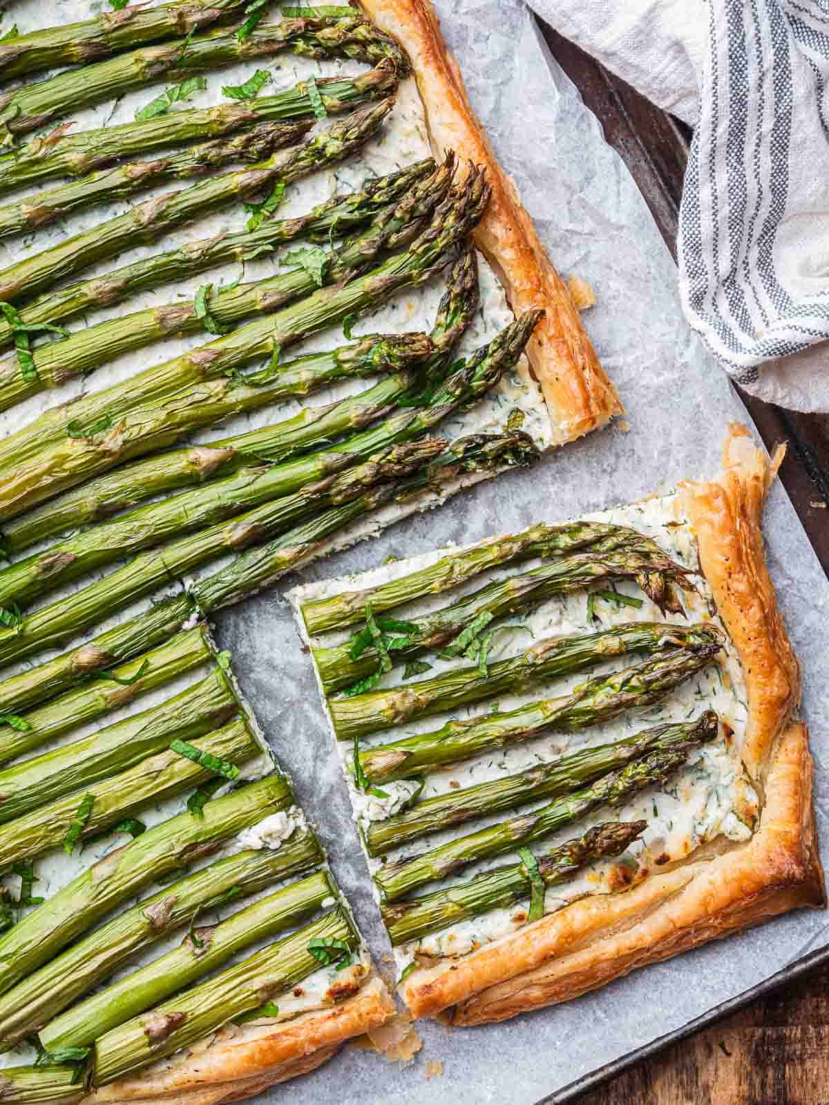 asparagus ricotta tart with puff pastry, with a slice cut off.