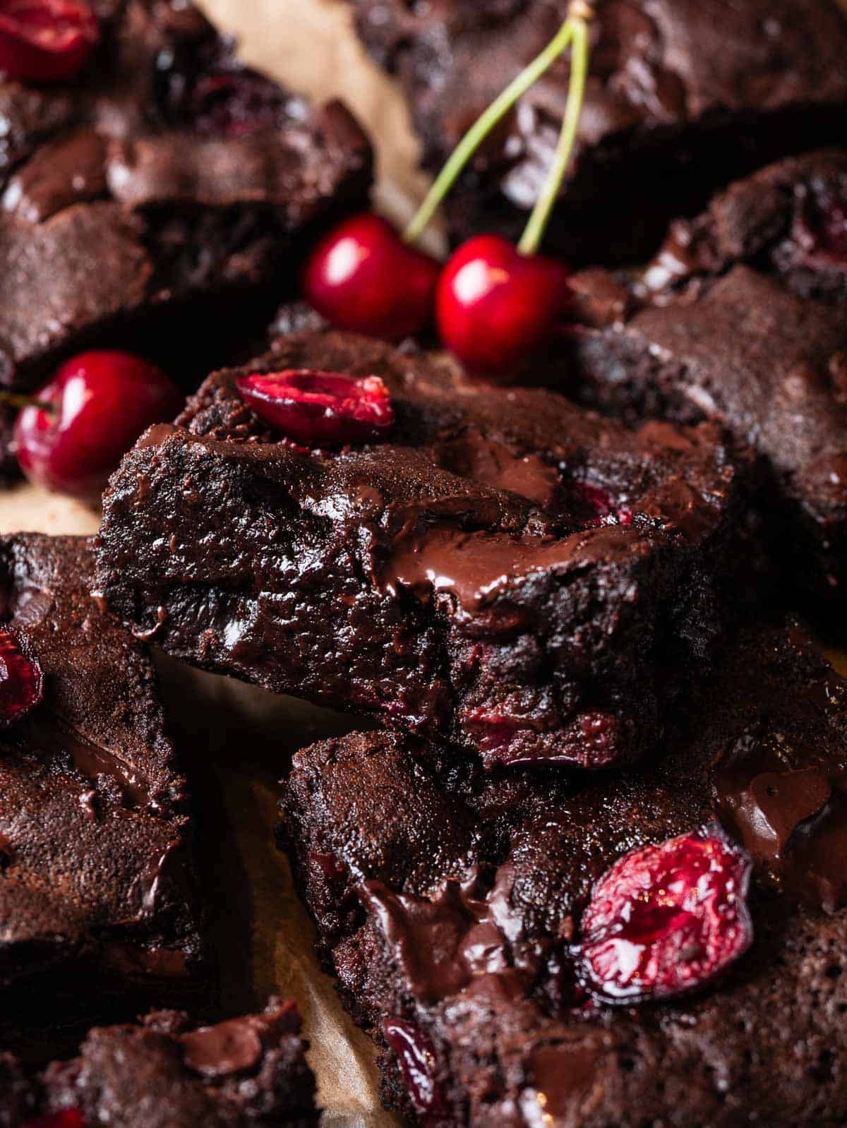 a square of fudgy cherry chocolate brownies on top of other squares.