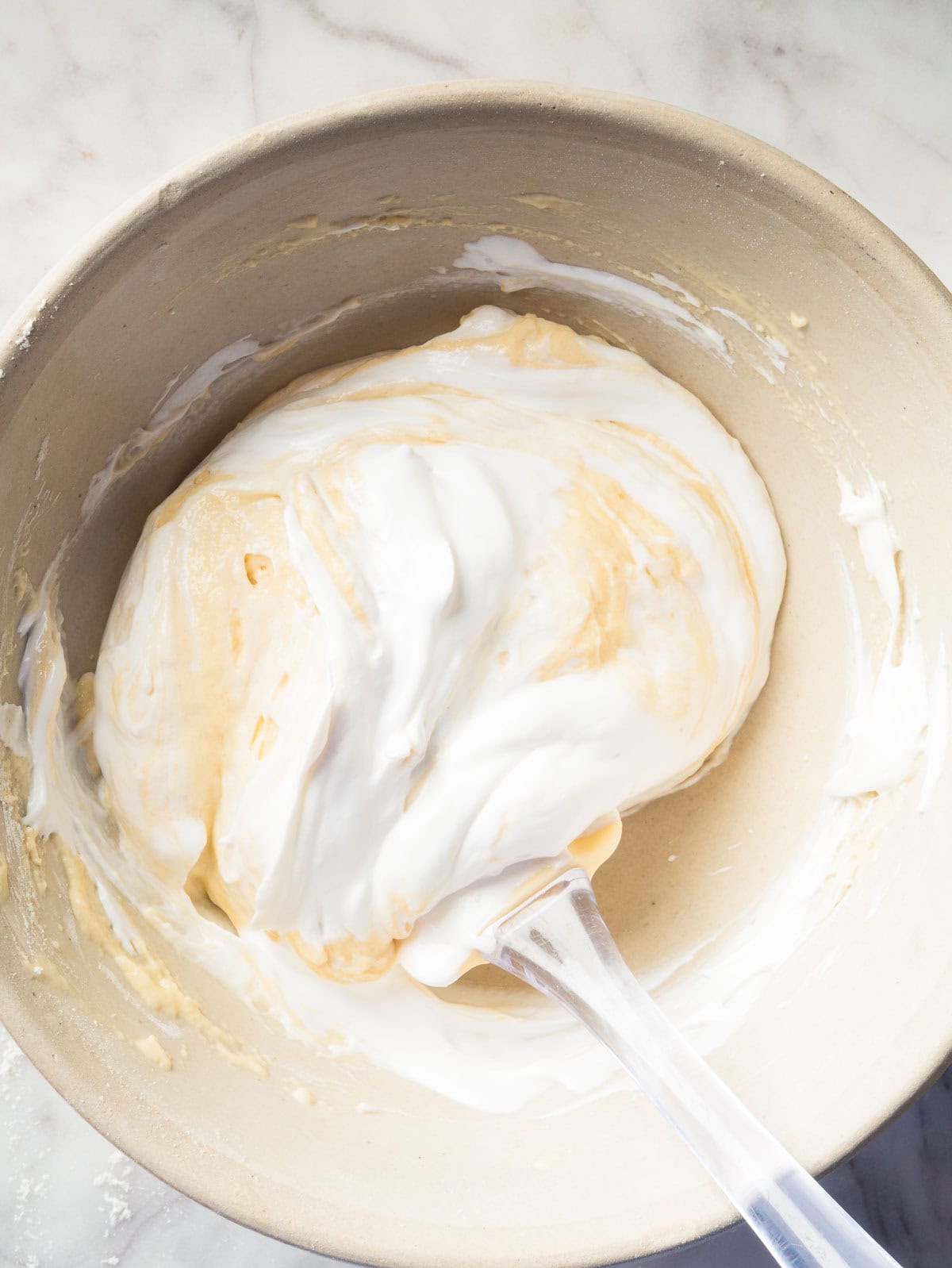 spatula folding meringue in pancake batter.