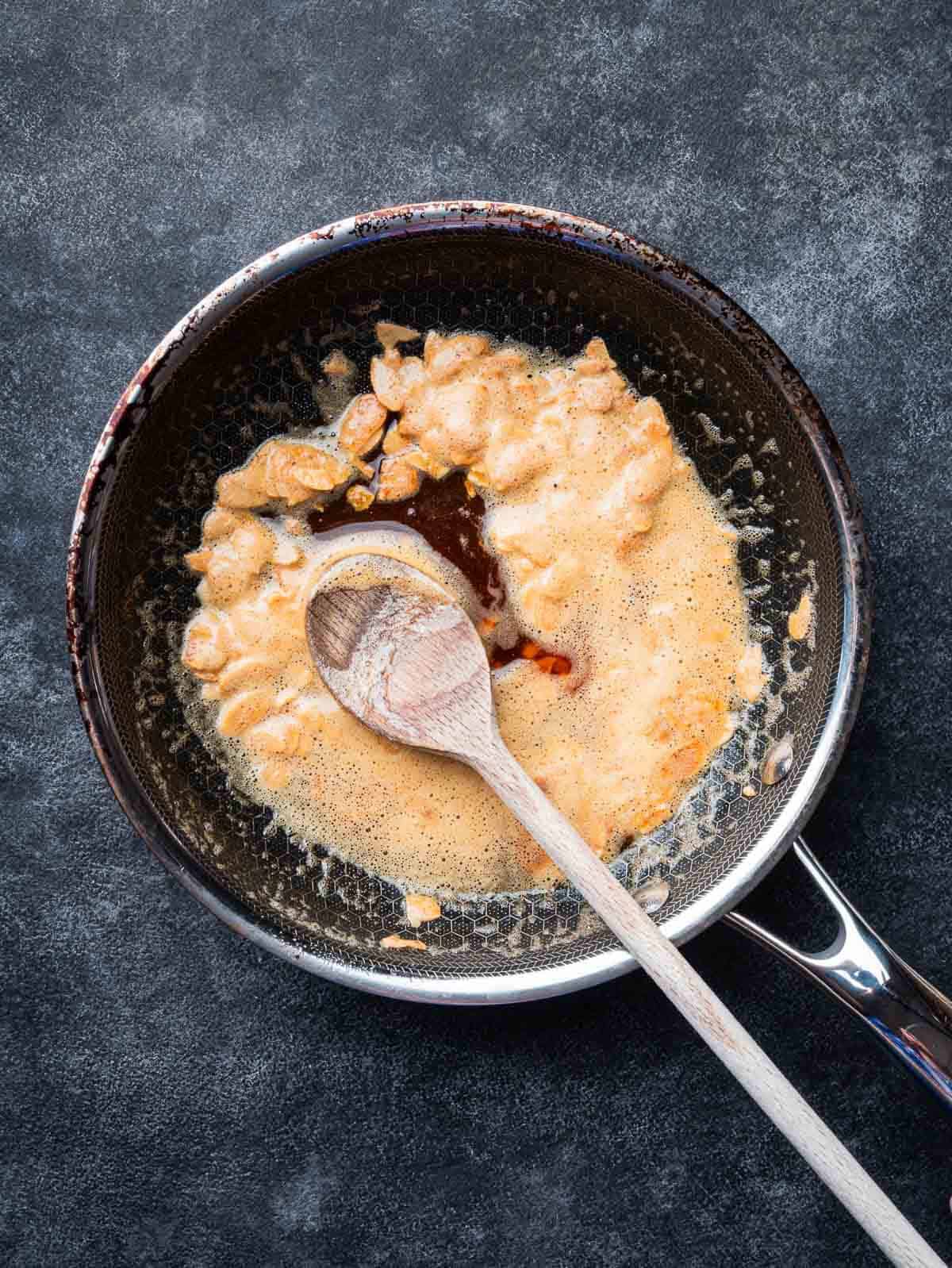 melted butter with smoked paprika and flaked almonds in a pan.