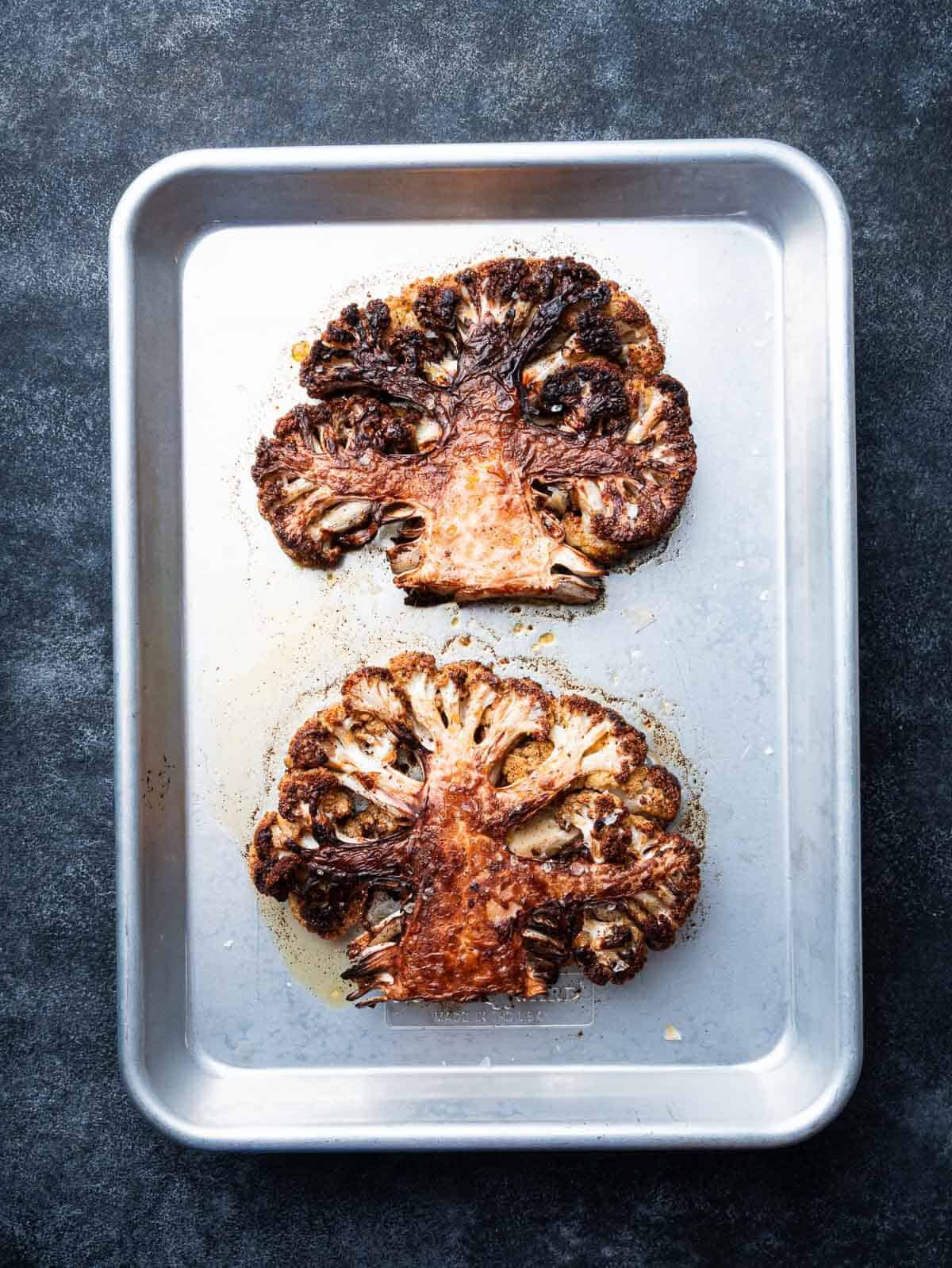 roasted cauliflower steaks on a sheet pan.