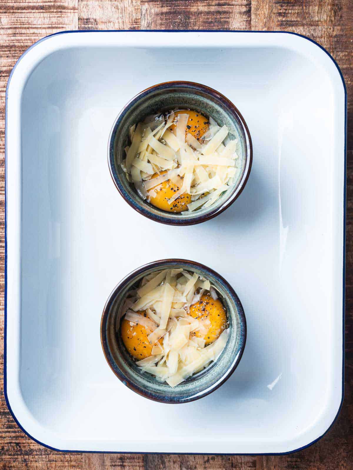 uncooked baked eggs on a baking sheet.