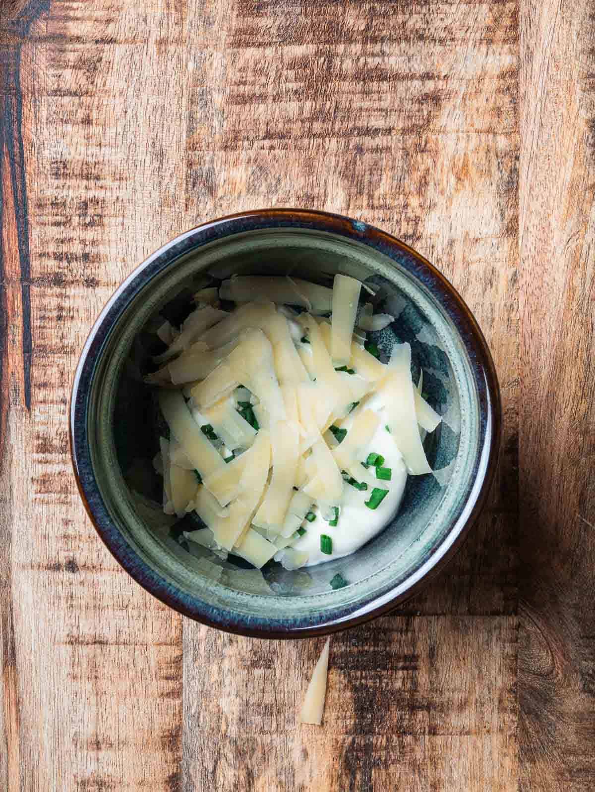 crème fraîche, chives and grated Comté cheese in a blue ramekin.
