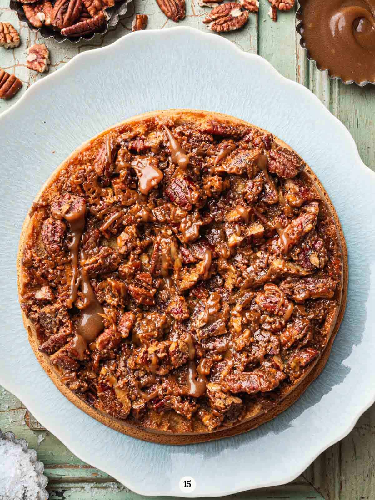 pecan upside down cake on a light blue serving platter.
