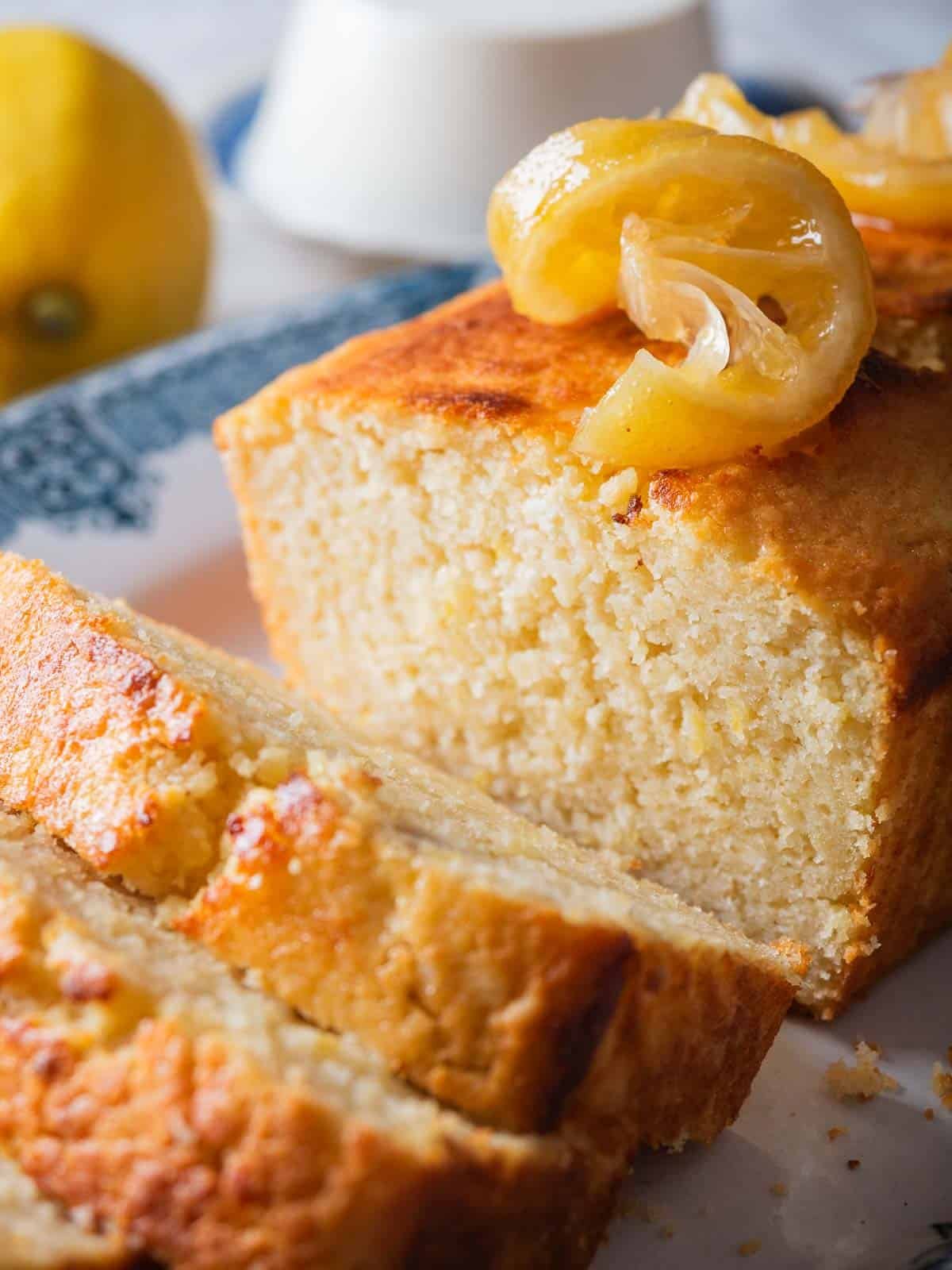 slices of lemon ricotta pound cake with the rest of the cake on a vintage blue plate.