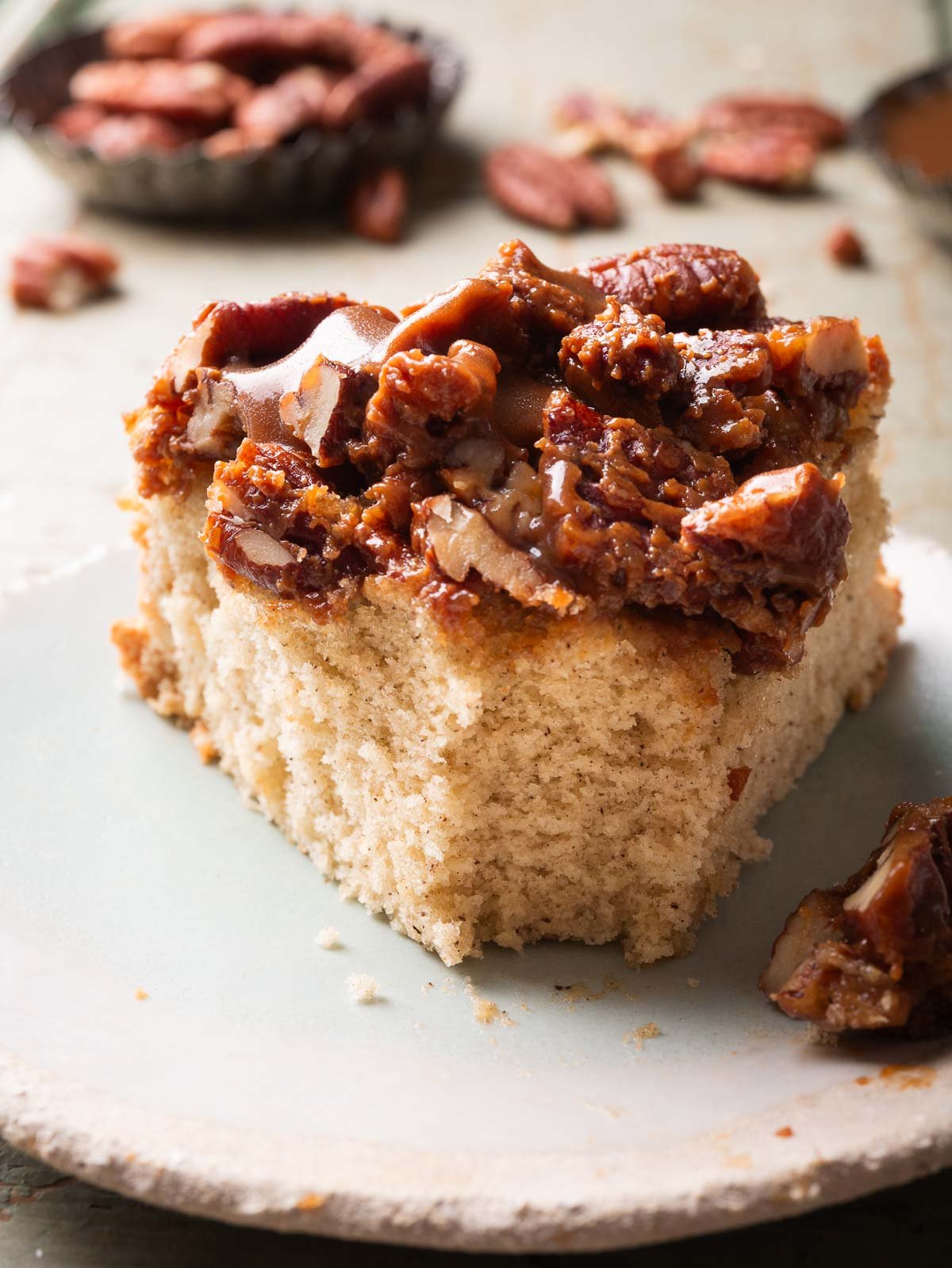 a slice of pecan upside down cake on a light blue plate.