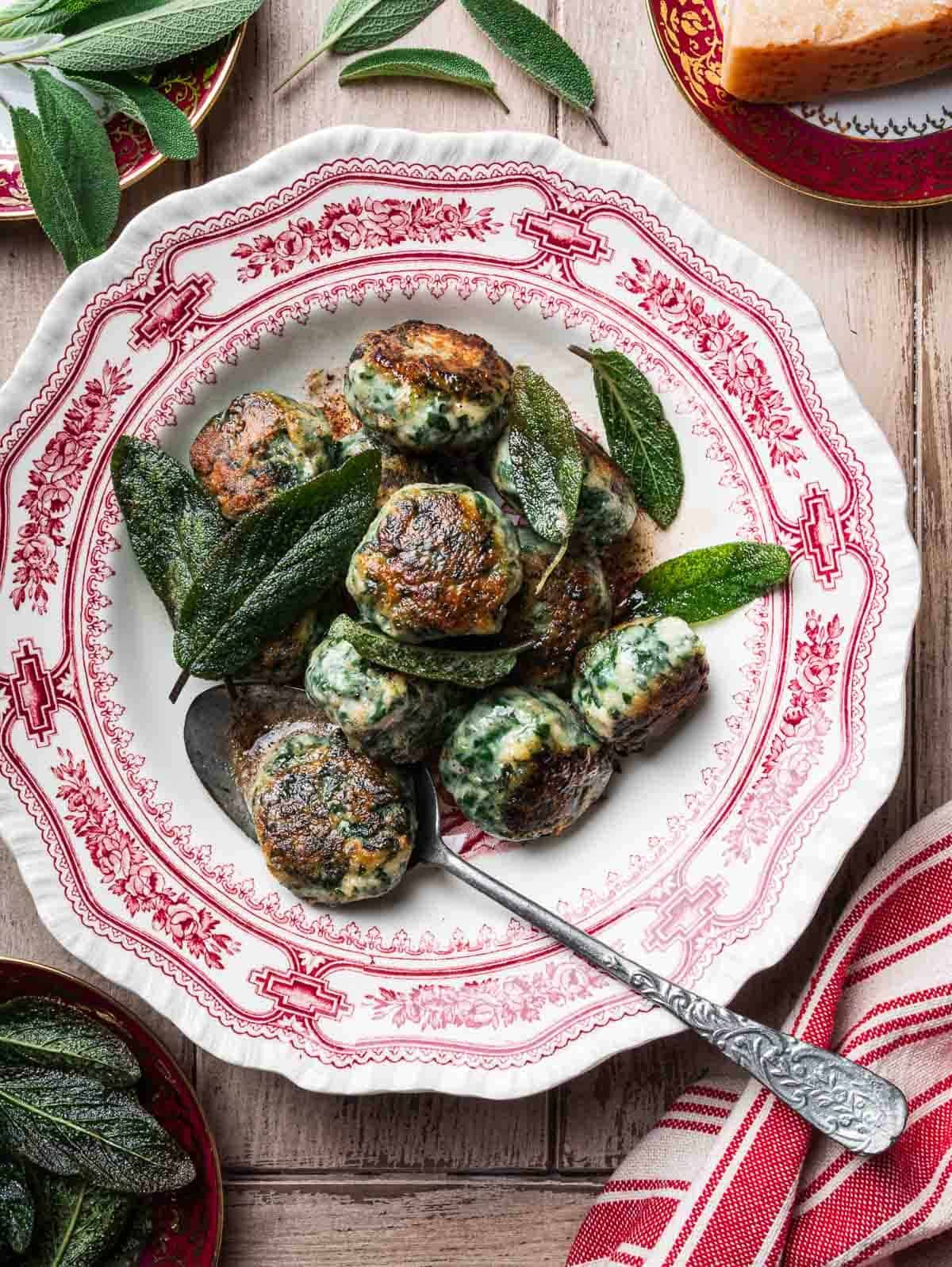 gnudi with crispy sage leaves in a vintage red and white plate.