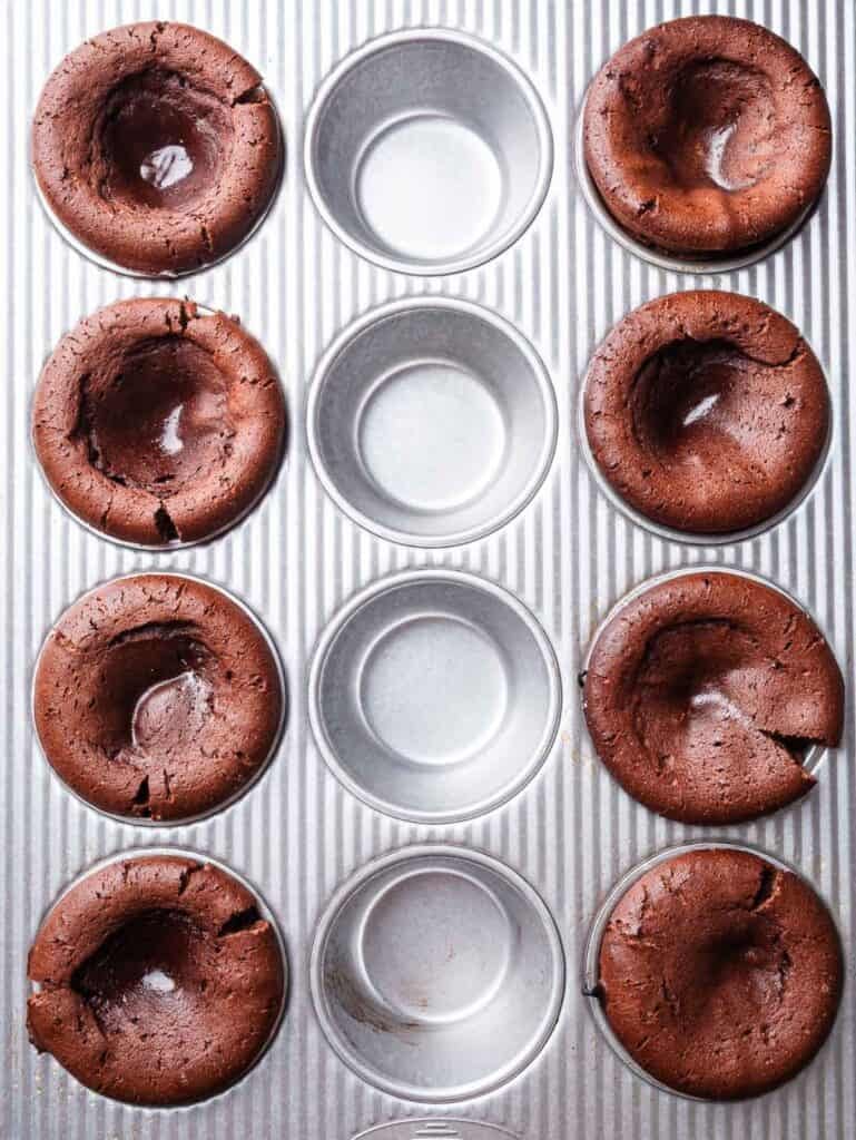 Baked chocolate lava cakes in a muffin tin.